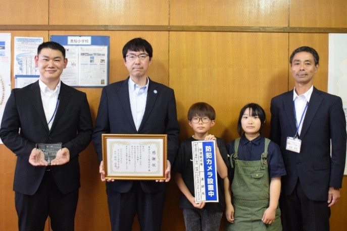 右より：岩垣校長先生、児童代表2名、望月社長